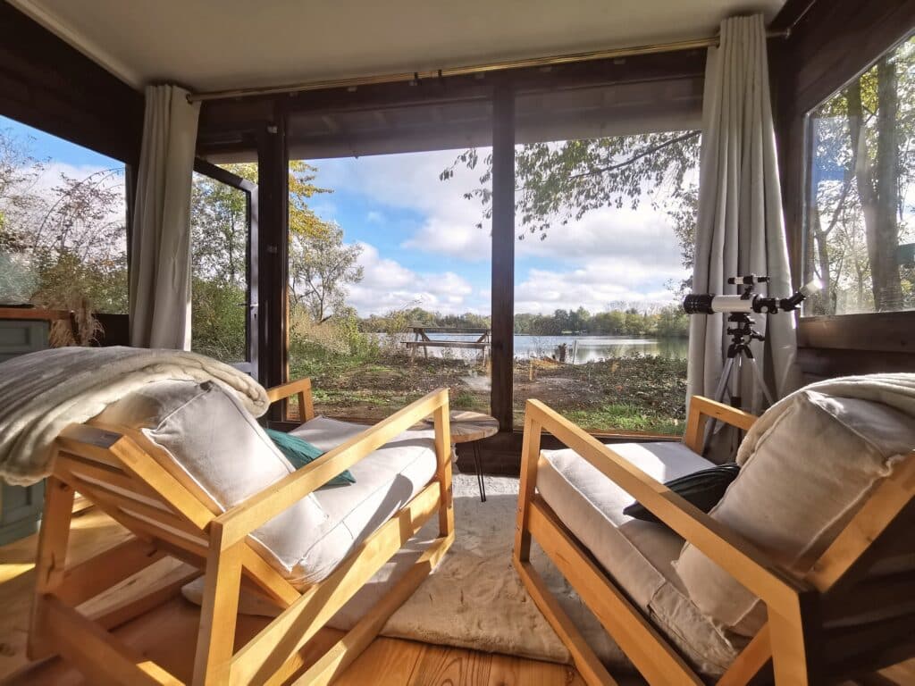 Vue sur le lac depuis la cabane du lac au domaine du Laurier Blanc près de Paris pour un réveil paisible en pleine nature. Week-end en amoureux près de Paris Pêche no kill